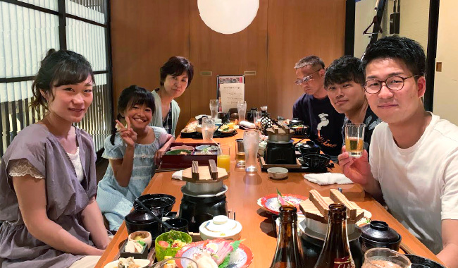 社員が家族と楽しそうに食事をしている写真